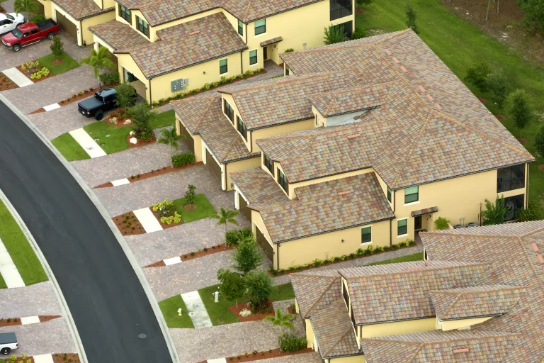 Aerial view of tile-roof homes with attached garages along a curved street