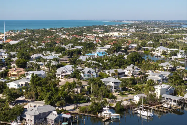 Aerial view of a waterfront neighborhood with docks and palm trees in southwest Florida