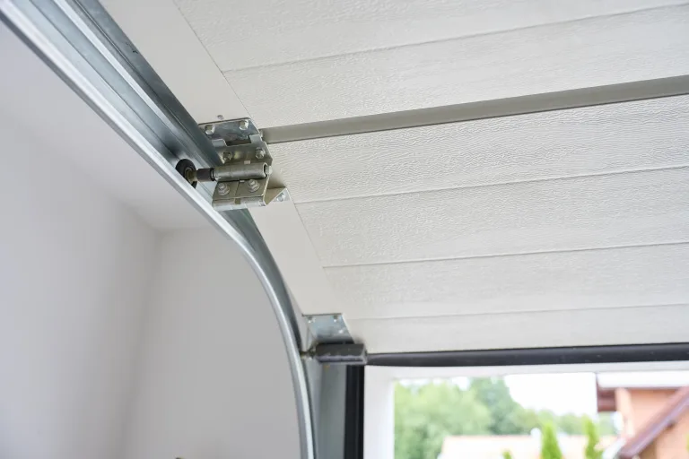 Garage door roller and hinge running in the curved metal track