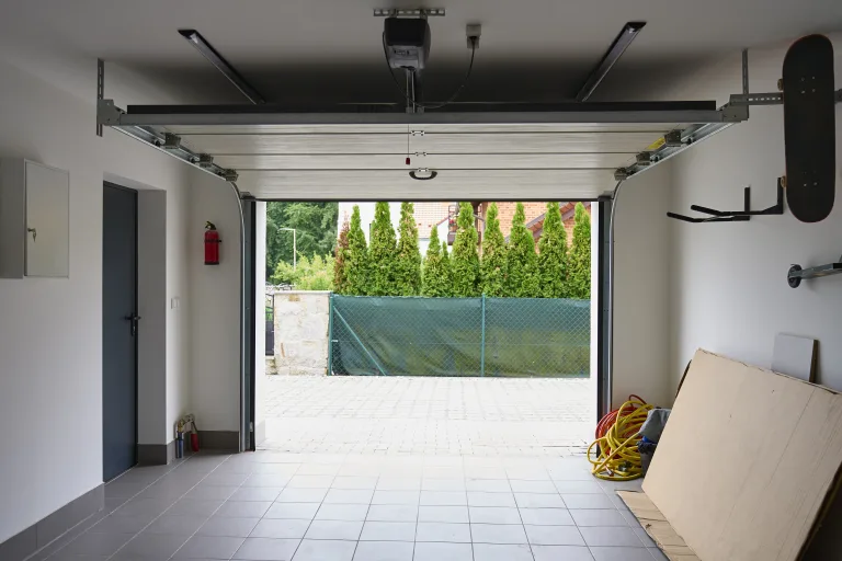 Open sectional garage door with the opener rail on the ceiling