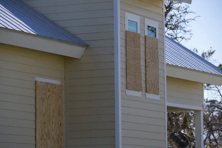 House windows boarded up with plywood before a hurricane