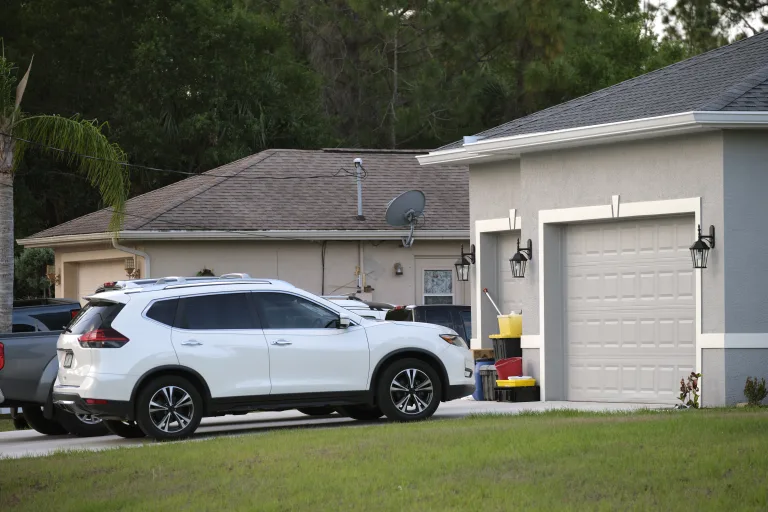 SUV parked on the driveway in front of a wide double garage door