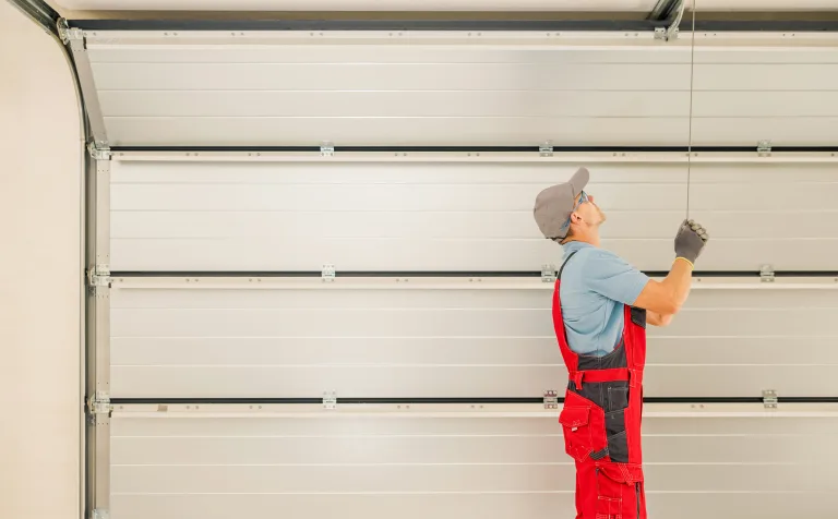 Technician checking the alignment of a residential garage door