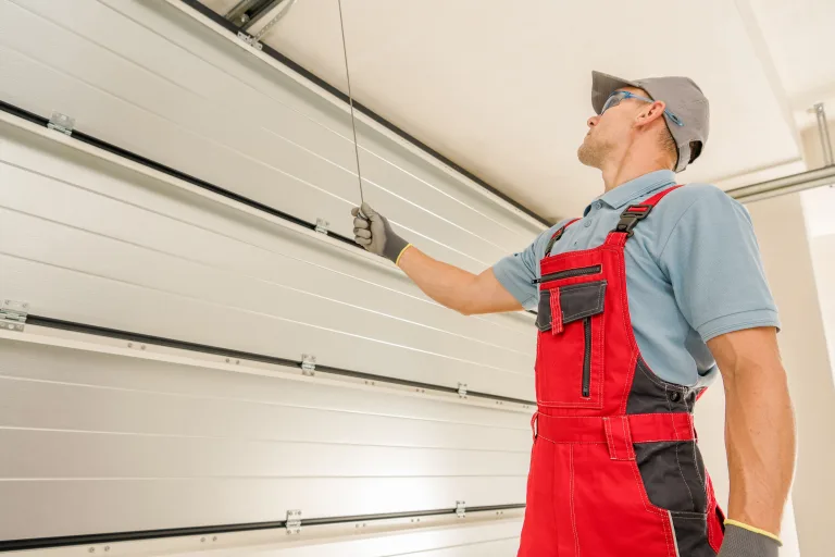 Technician testing a sectional garage door from inside the garage