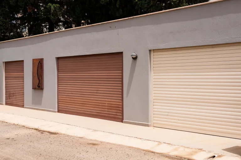 Two garage doors side by side, one brown and one beige