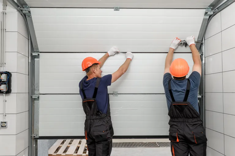 Two installers fitting a new sectional garage door